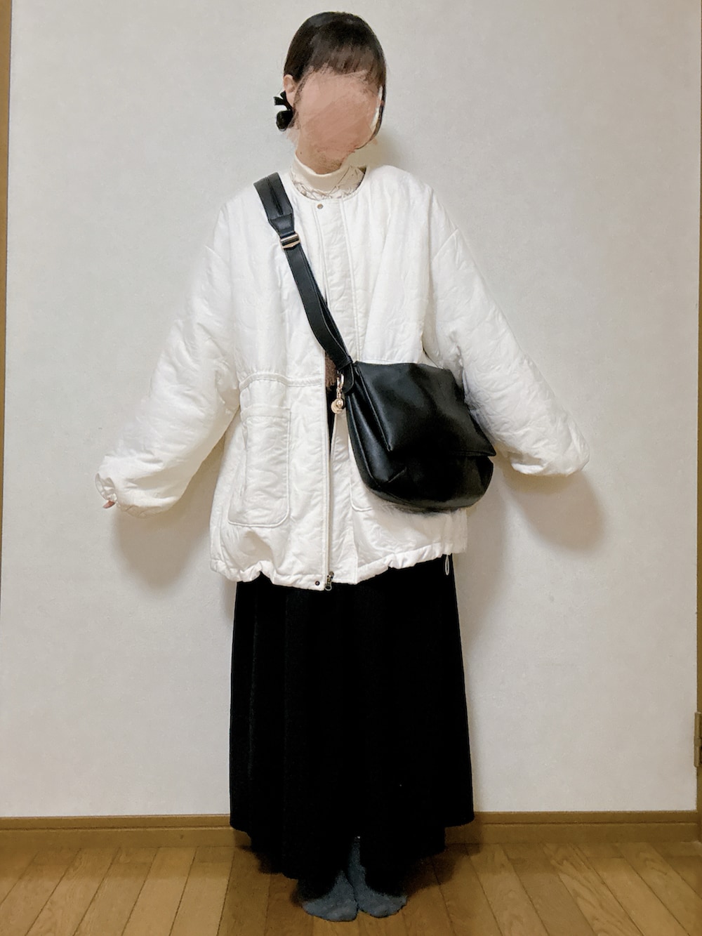 ブラウン系のカーディガン/ボレロ、ブラック系のワンピース、ブラウン系のローファーを着用したレディースの秋コーディネートの2枚目の写真