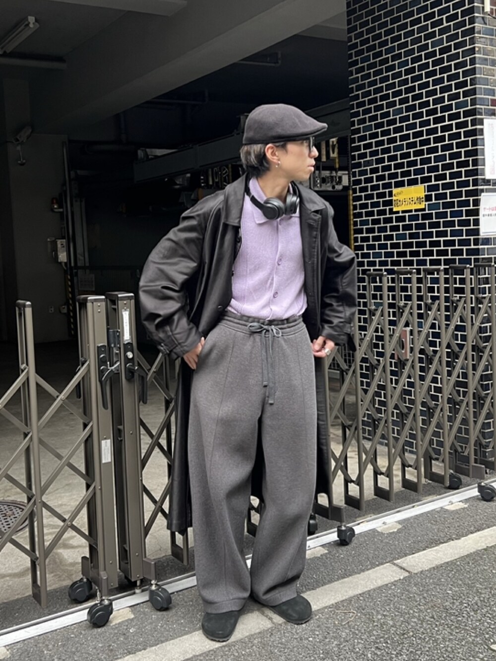 ブラック系のステンカラーコート、グレー系のスラックス、ブラック系のサンダルを着用したメンズの冬コーディネートの2枚目の写真