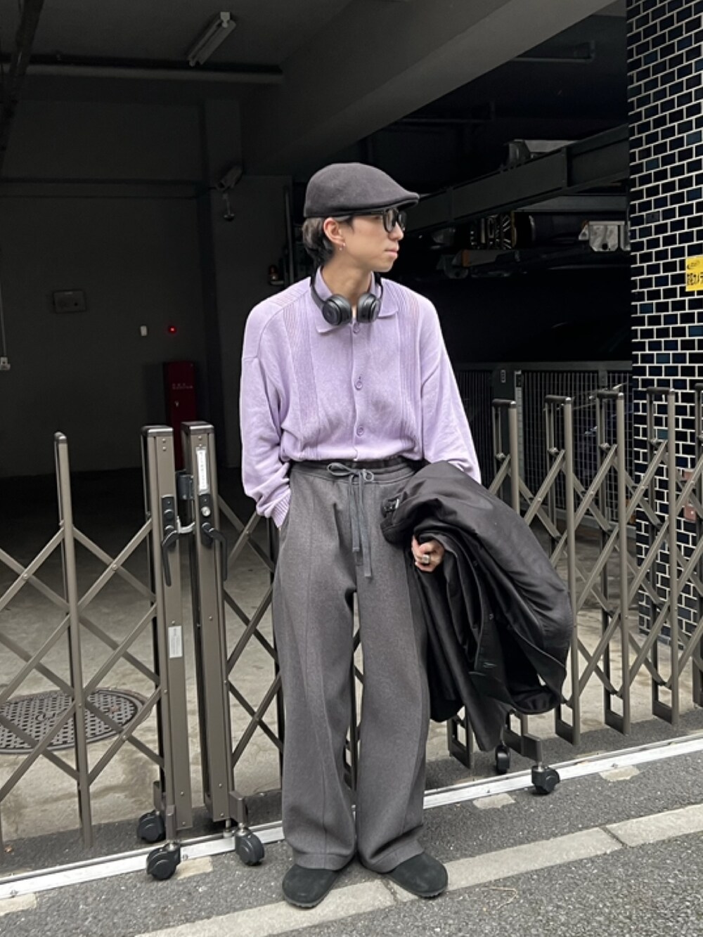 ブラック系のステンカラーコート、グレー系のスラックス、ブラック系のサンダルを着用したメンズの冬コーディネートの4枚目の写真