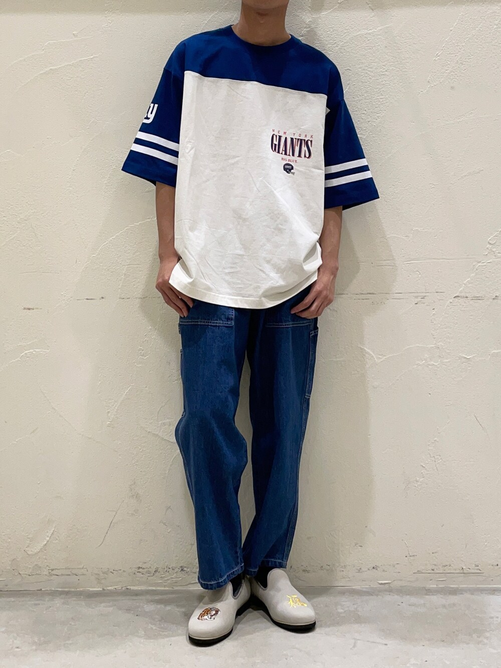 ブルー系のTシャツ/カットソー、ブルー系のデニムパンツ、グレー系のスリッポンを着用したメンズの春コーディネートの3枚目の写真