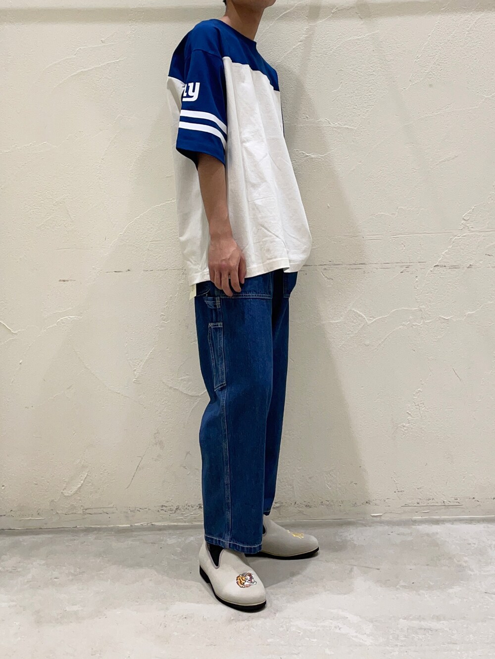 ブルー系のTシャツ/カットソー、ブルー系のデニムパンツ、グレー系のスリッポンを着用したメンズの春コーディネートの4枚目の写真