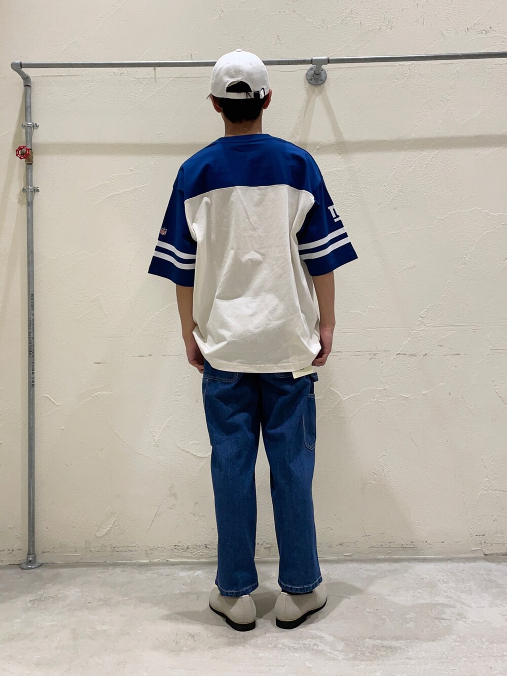 ブルー系のTシャツ/カットソー、ブルー系のデニムパンツ、グレー系のスリッポンを着用したメンズの春コーディネートの2枚目の写真