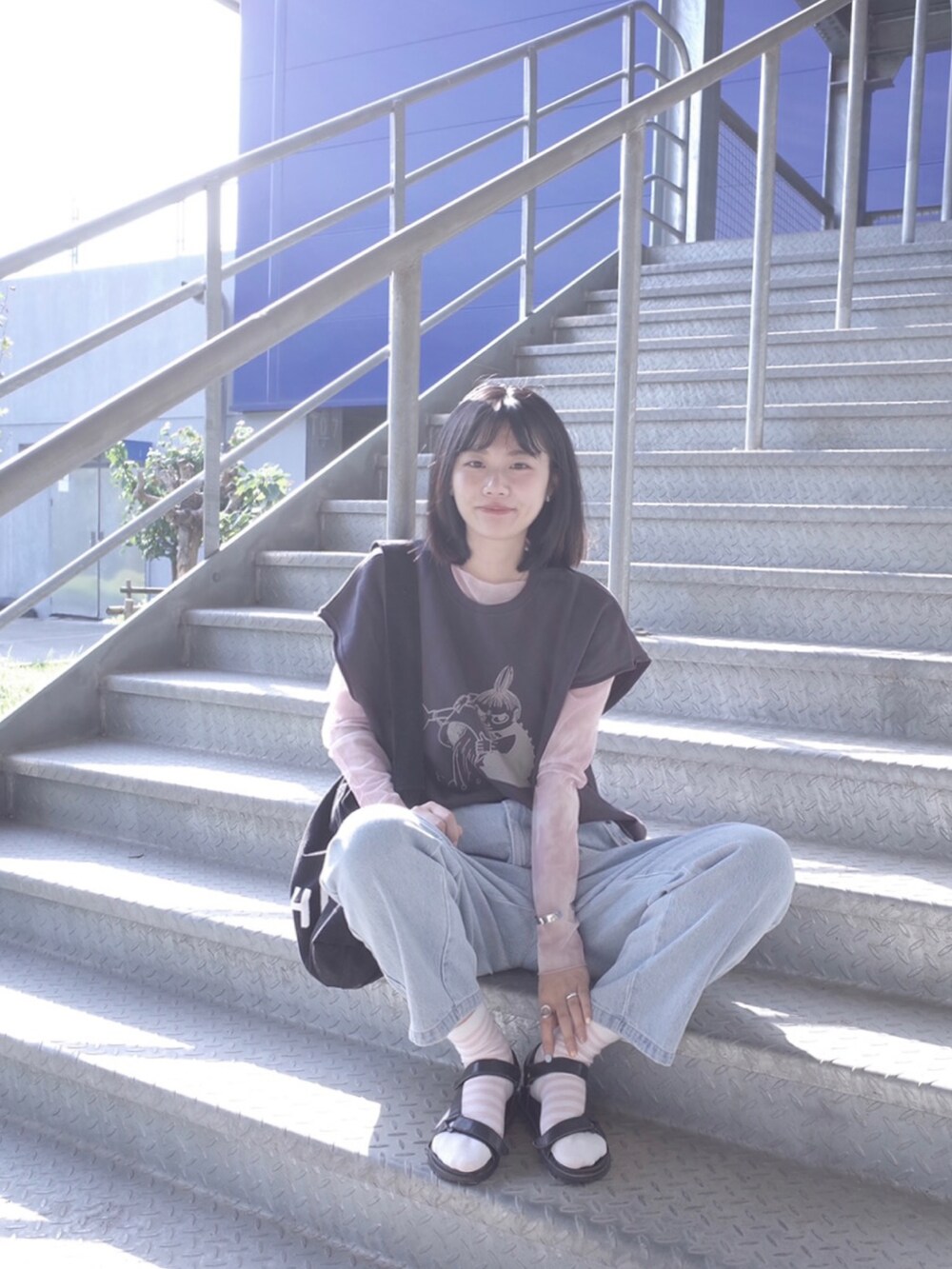 グレー系のベスト、ブルー系のその他パンツ、ブラック系のショルダーバッグを着用したレディースの秋コーディネートの2枚目の写真