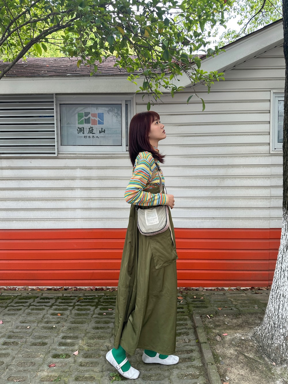 イエロー系のTシャツ/カットソー、グリーン系のジャンパースカートを着用したレディースの春コーディネートの3枚目の写真