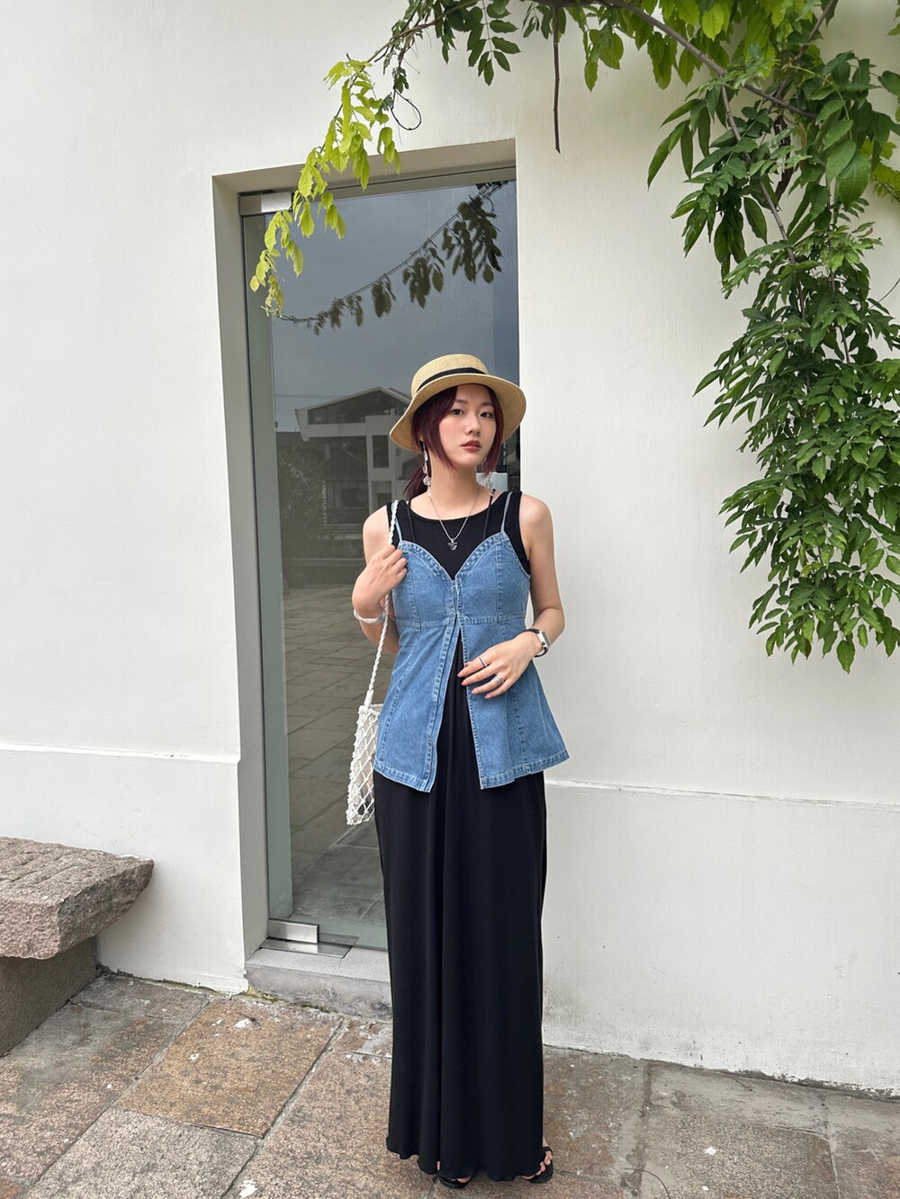 ブルー系のキャミソール、ブラック系のワンピース、ホワイト系のショルダーバッグを着用したレディースの夏コーディネートの2枚目の写真