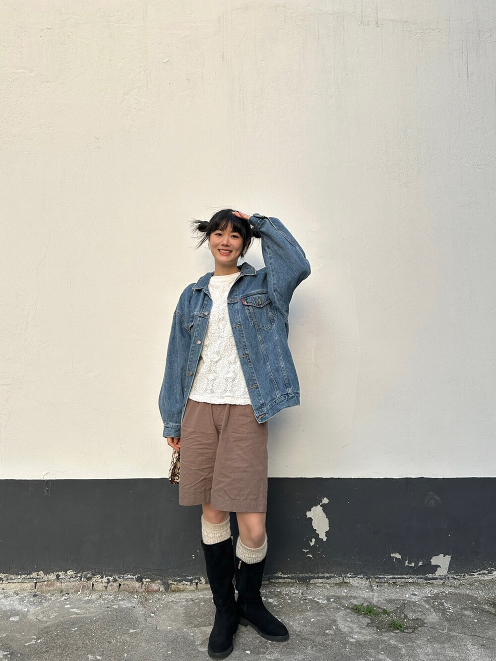 ブルー系のデニムジャケット、ブラウン系のその他パンツ、ベージュ系のショルダーバッグを着用したレディースの春コーディネートの2枚目の写真