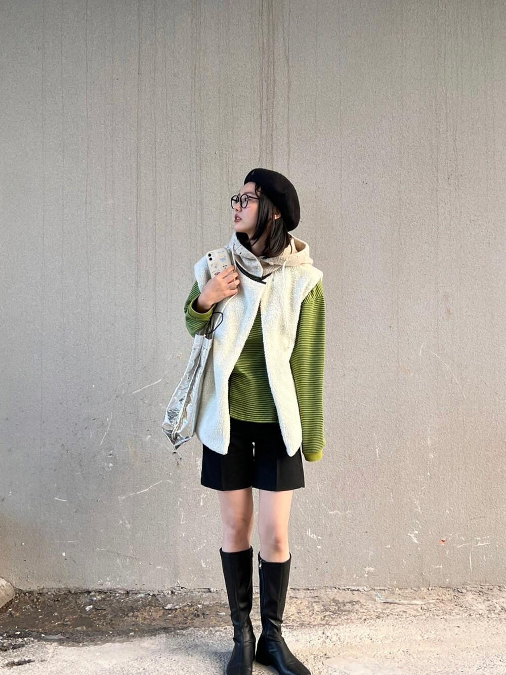 グリーン系のTシャツ/カットソー、ブラック系のベスト、ブラック系のその他パンツを着用したレディースの秋コーディネートの3枚目の写真