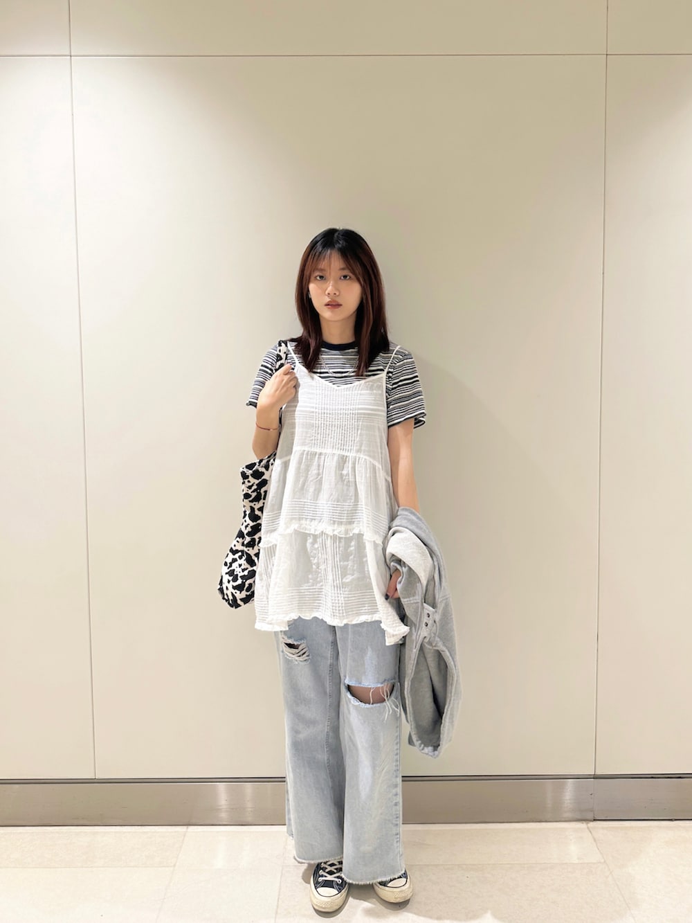 グリーン系のTシャツ/カットソー、ホワイト系のシャツ/ブラウス、グレー系のカーディガン/ボレロを着用したレディースの秋コーディネートの2枚目の写真