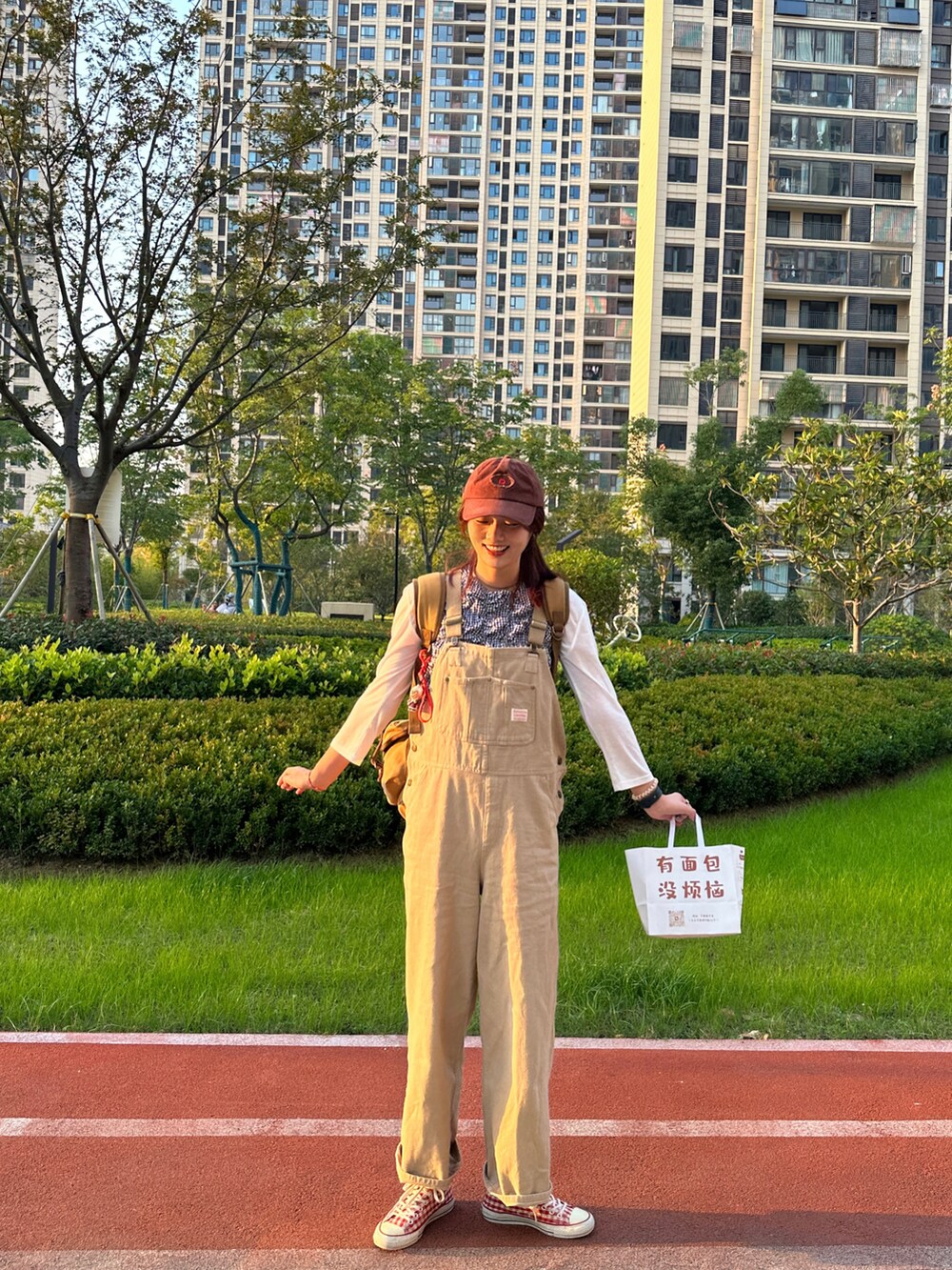 ベージュ系のサロペット/オーバーオール、レッド系のスニーカー、その他のシャツ/ブラウスを着用したレディースの秋コーディネートの2枚目の写真