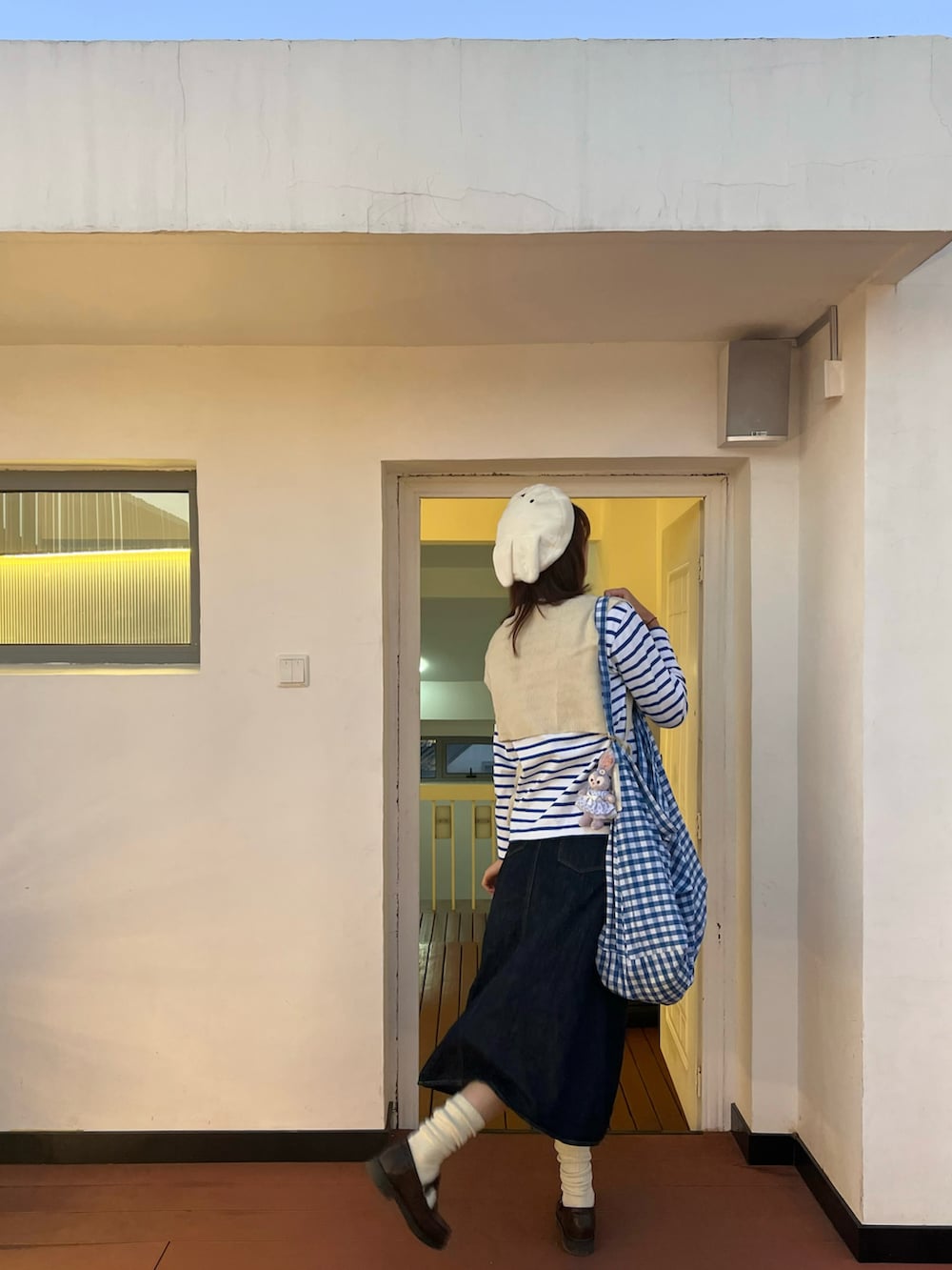 ブルー系のデニムスカート、ブルー系のTシャツ/カットソー、ブルー系のショルダーバッグを着用したレディースの冬コーディネートの3枚目の写真