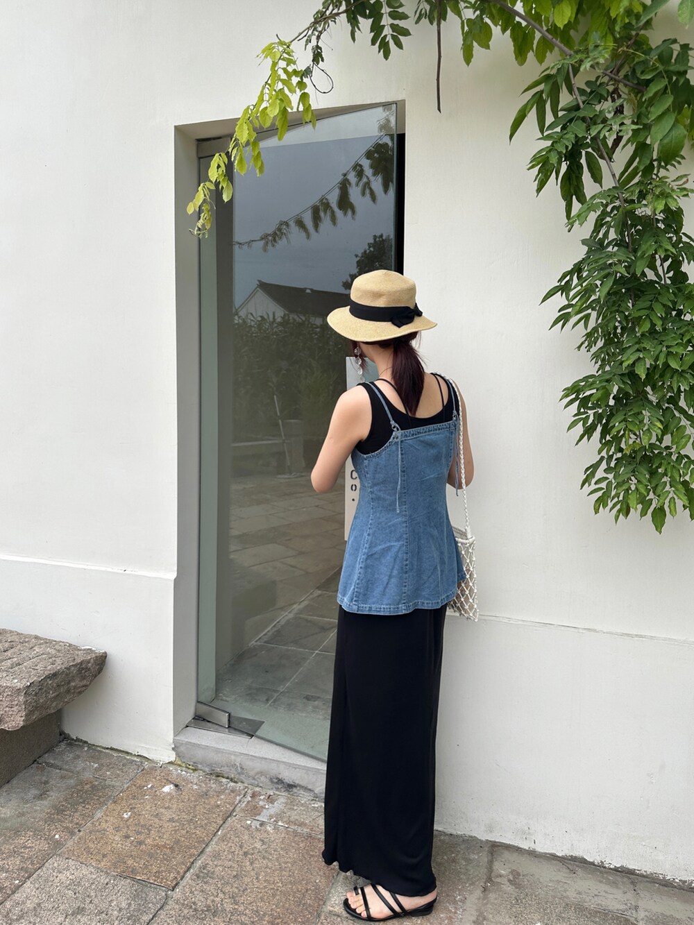ブルー系のキャミソール、ブラック系のワンピース、ホワイト系のショルダーバッグを着用したレディースの夏コーディネートの3枚目の写真