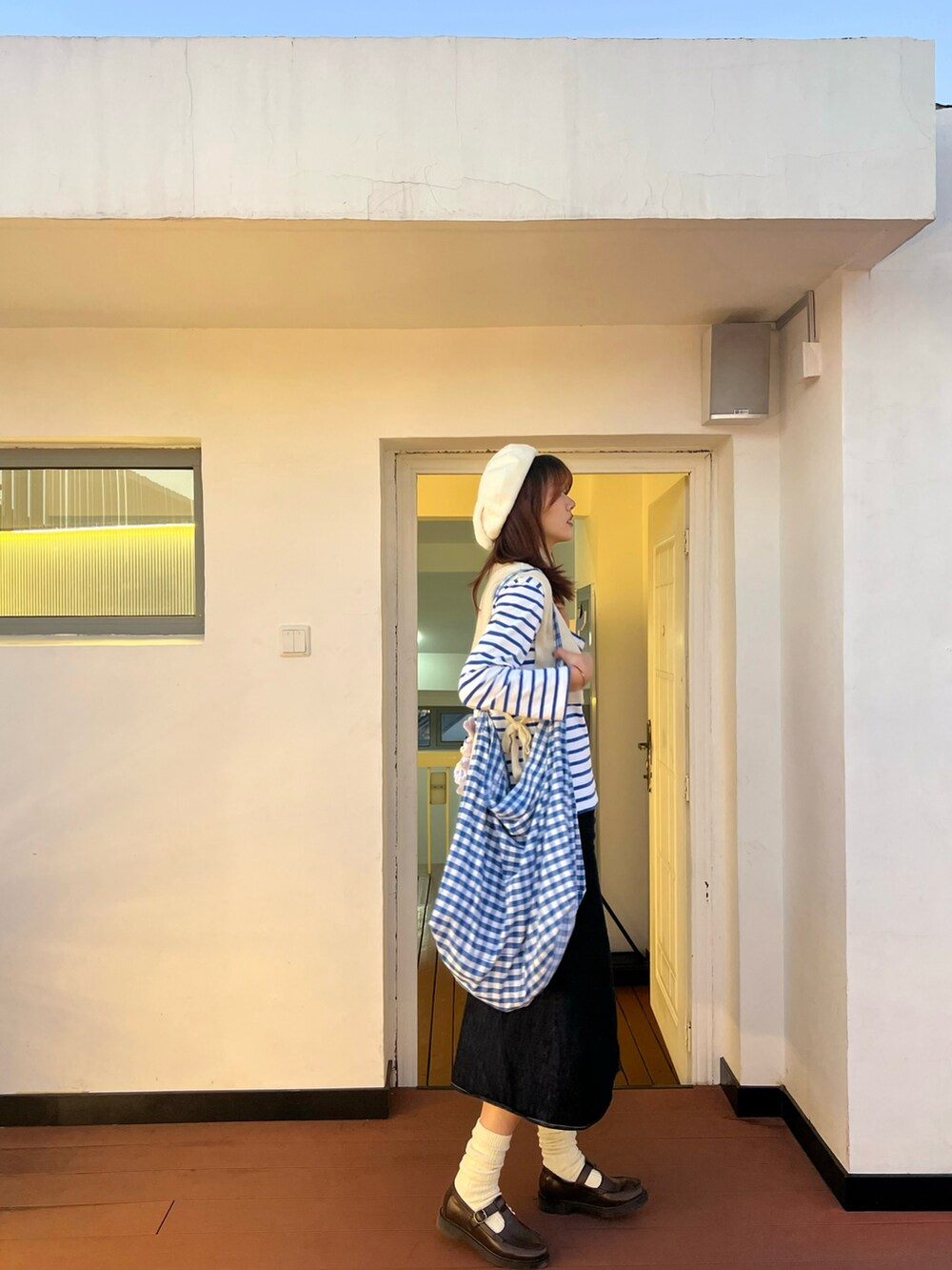 ブルー系のデニムスカート、ブルー系のTシャツ/カットソー、ブルー系のショルダーバッグを着用したレディースの冬コーディネートの2枚目の写真