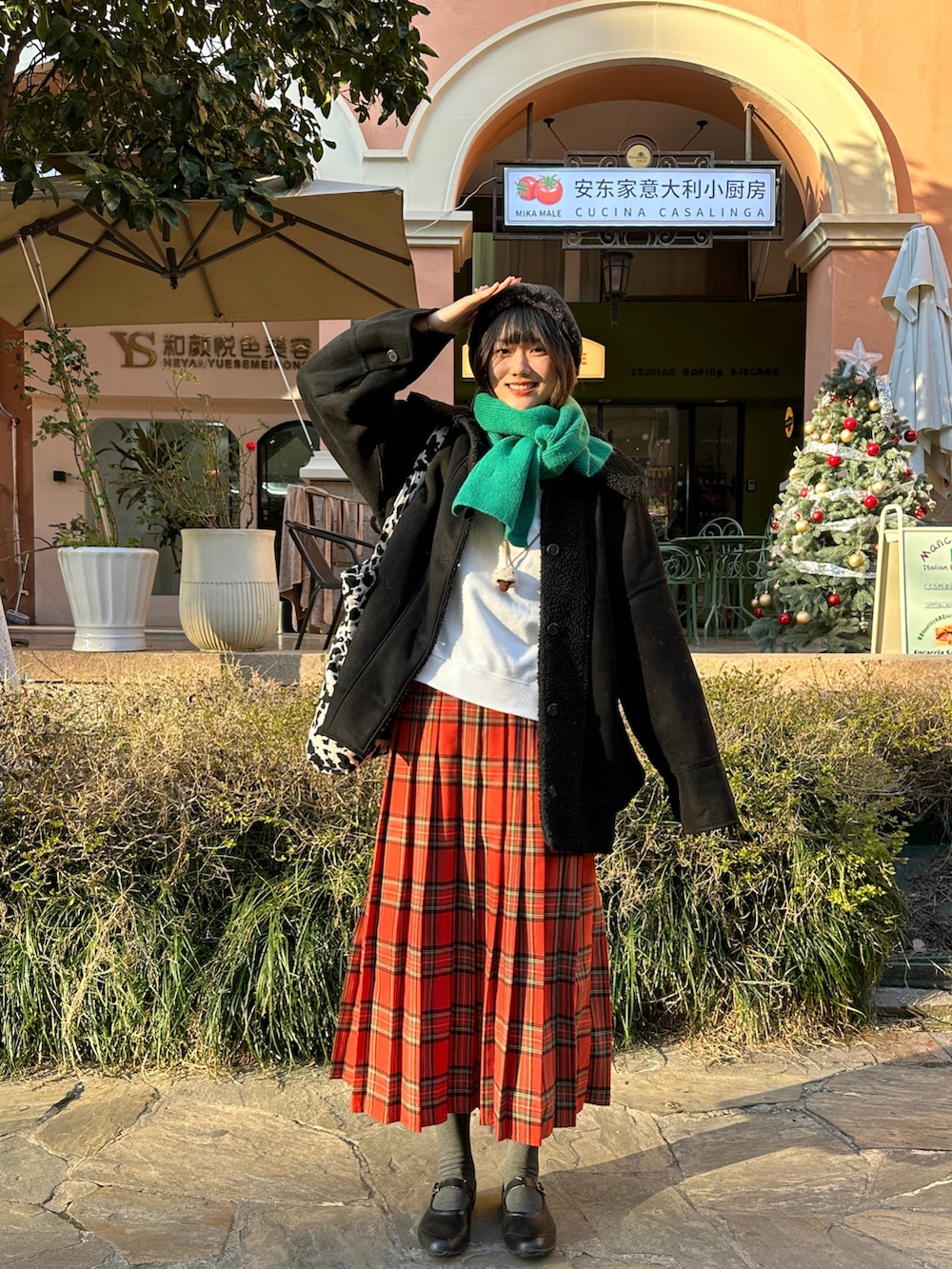 レッド系のスカート、ブラック系のレインシューズ、ホワイト系のスウェットを着用したレディースの冬コーディネートの2枚目の写真