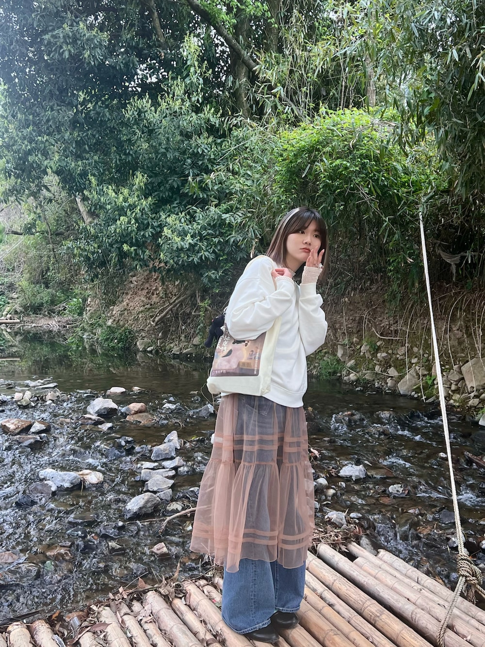 ベージュ系のワンピース、ブルー系のデニムパンツ、ホワイト系のその他トップスを着用したレディースの春コーディネートの3枚目の写真