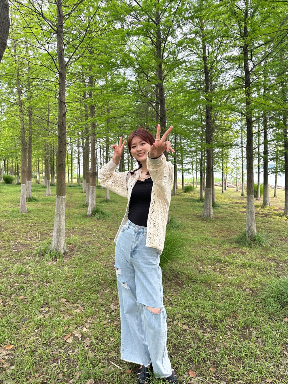 ブルー系のデニムパンツ、ホワイト系のシャツ/ブラウス、ブラック系のサンダルを着用したレディースの夏コーディネートの2枚目の写真