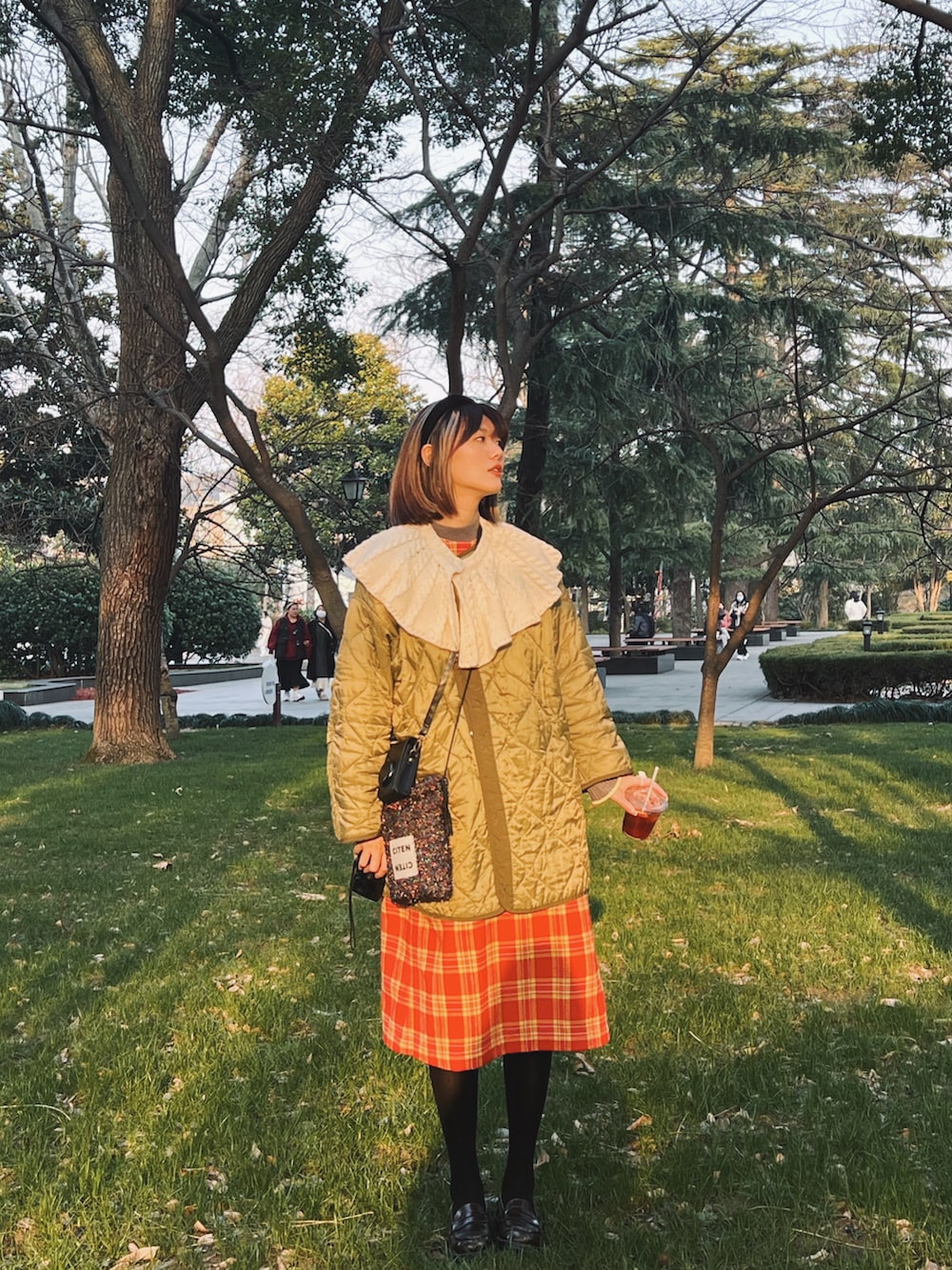 グリーン系のミリタリージャケット、その他のショルダーバッグ、レッド系のワンピースを着用したレディースの春コーディネートの2枚目の写真