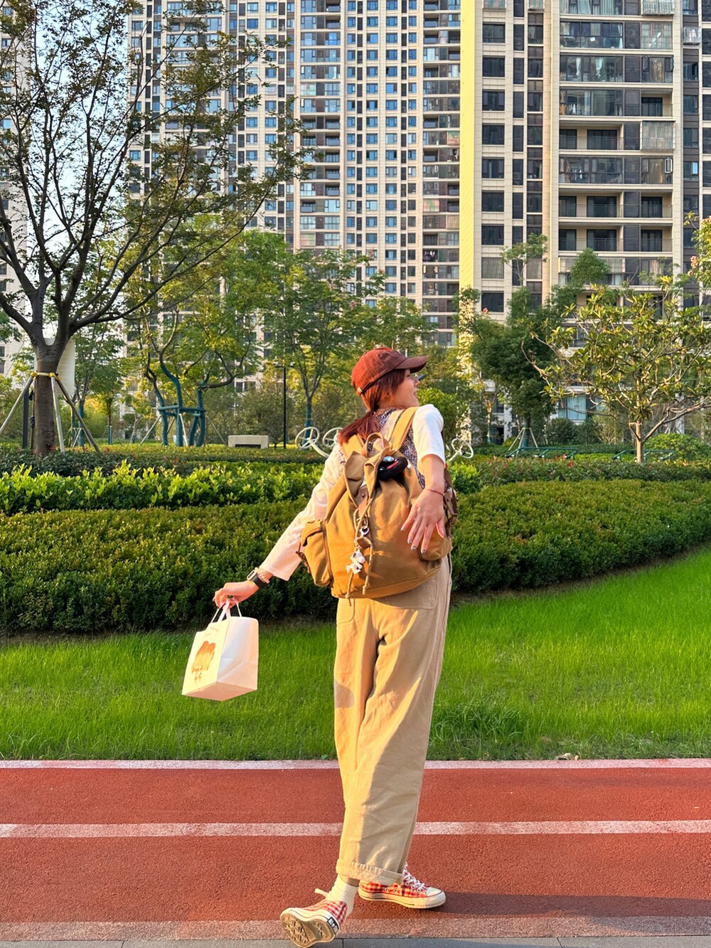 ベージュ系のサロペット/オーバーオール、レッド系のスニーカー、その他のシャツ/ブラウスを着用したレディースの秋コーディネートの3枚目の写真