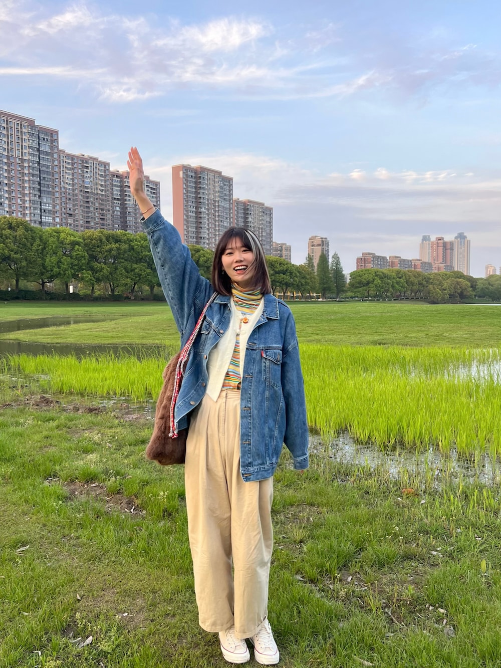 ホワイト系のベスト、イエロー系のTシャツ/カットソー、ホワイト系のスニーカーを着用したレディースの春コーディネートの2枚目の写真