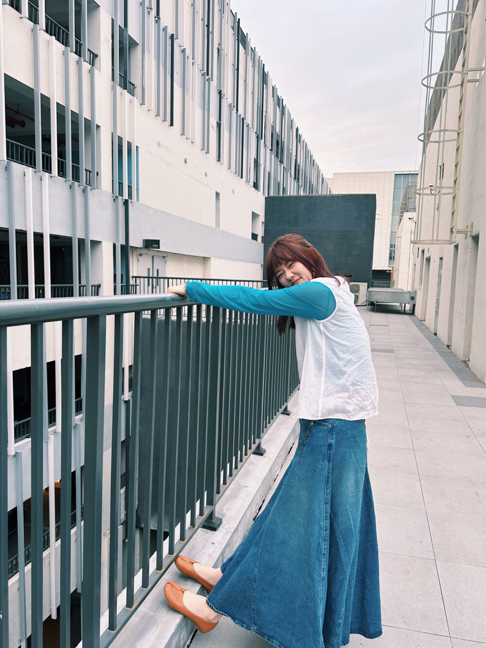 ホワイト系のシャツ/ブラウス、ブルー系のデニムスカート、ブルー系のTシャツ/カットソーを着用したレディースの春コーディネートの2枚目の写真