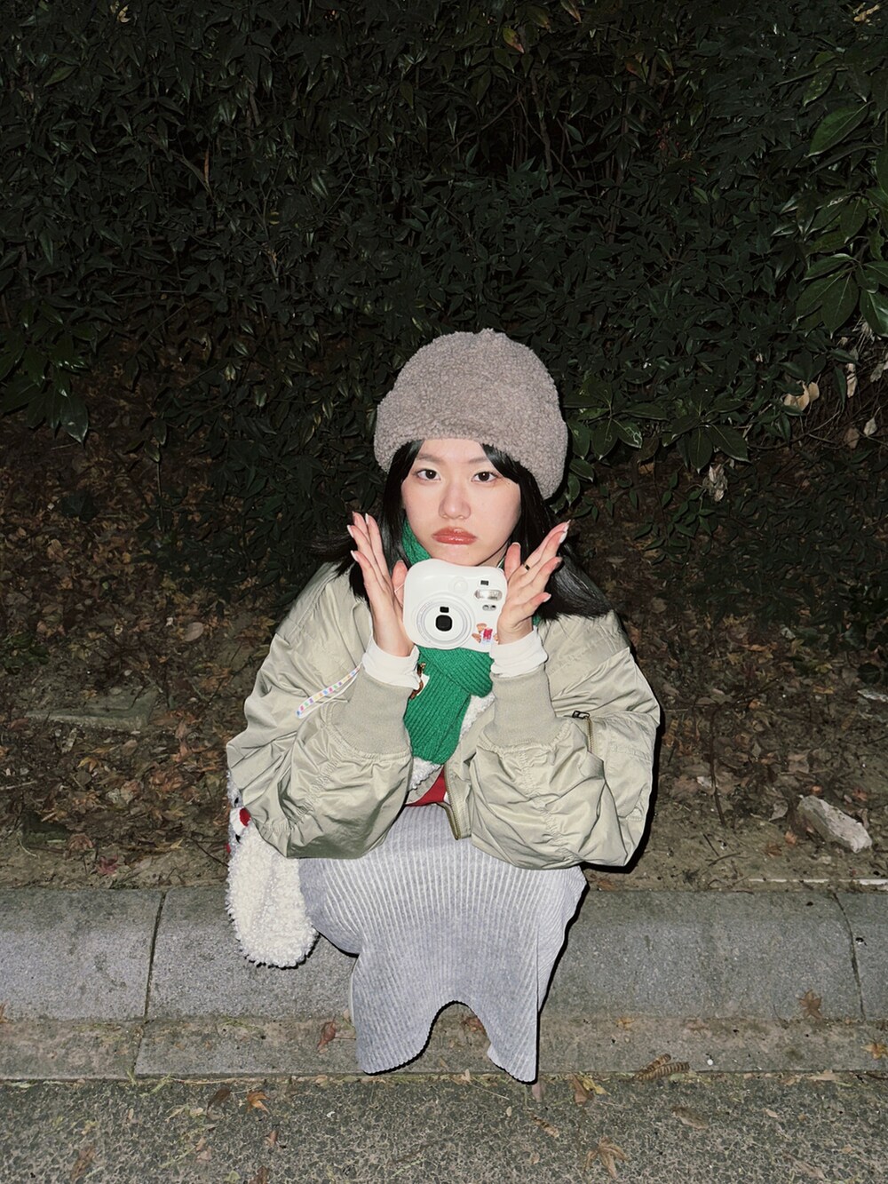 グリーン系のブルゾン、レッド系のスウェット、ホワイト系のTシャツ/カットソーを着用したレディースの冬コーディネートの3枚目の写真