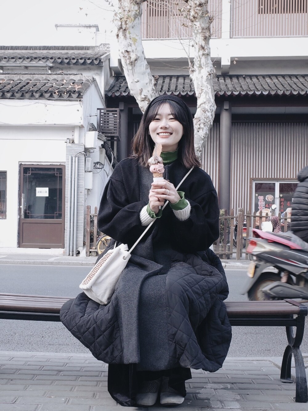 ブラック系のその他アウター、グリーン系のTシャツ/カットソー、ホワイト系のニット/セーターを着用したレディースの冬コーディネートの2枚目の写真