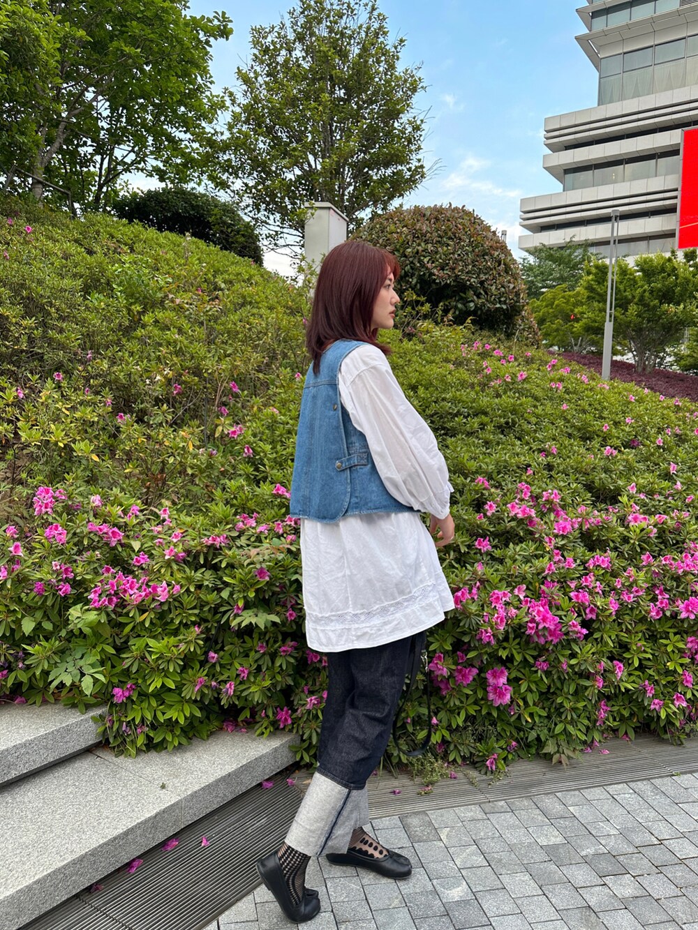 ブルー系のベスト、ホワイト系のシャツ/ブラウス、ブルー系のデニムパンツを着用したレディースの春コーディネートの4枚目の写真