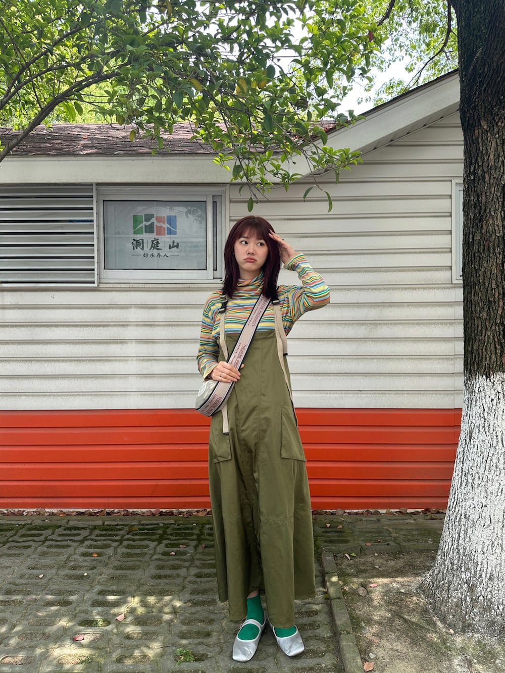 イエロー系のTシャツ/カットソー、グリーン系のジャンパースカートを着用したレディースの春コーディネートの2枚目の写真