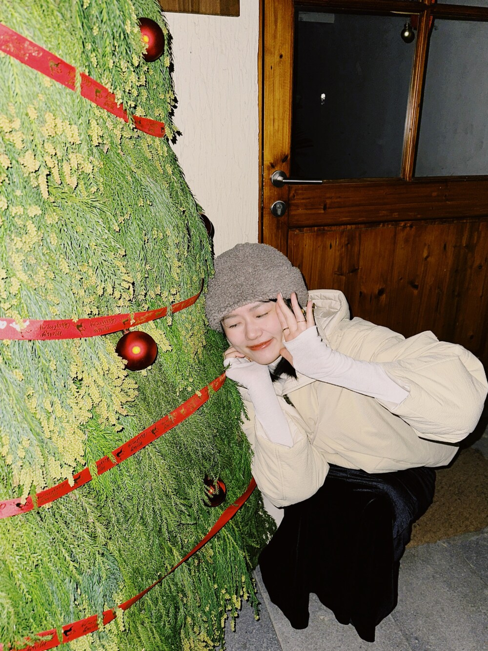 イエロー系のブルゾン、ブラック系のワンピース、ホワイト系のTシャツ/カットソーを着用したレディースの冬コーディネートの2枚目の写真