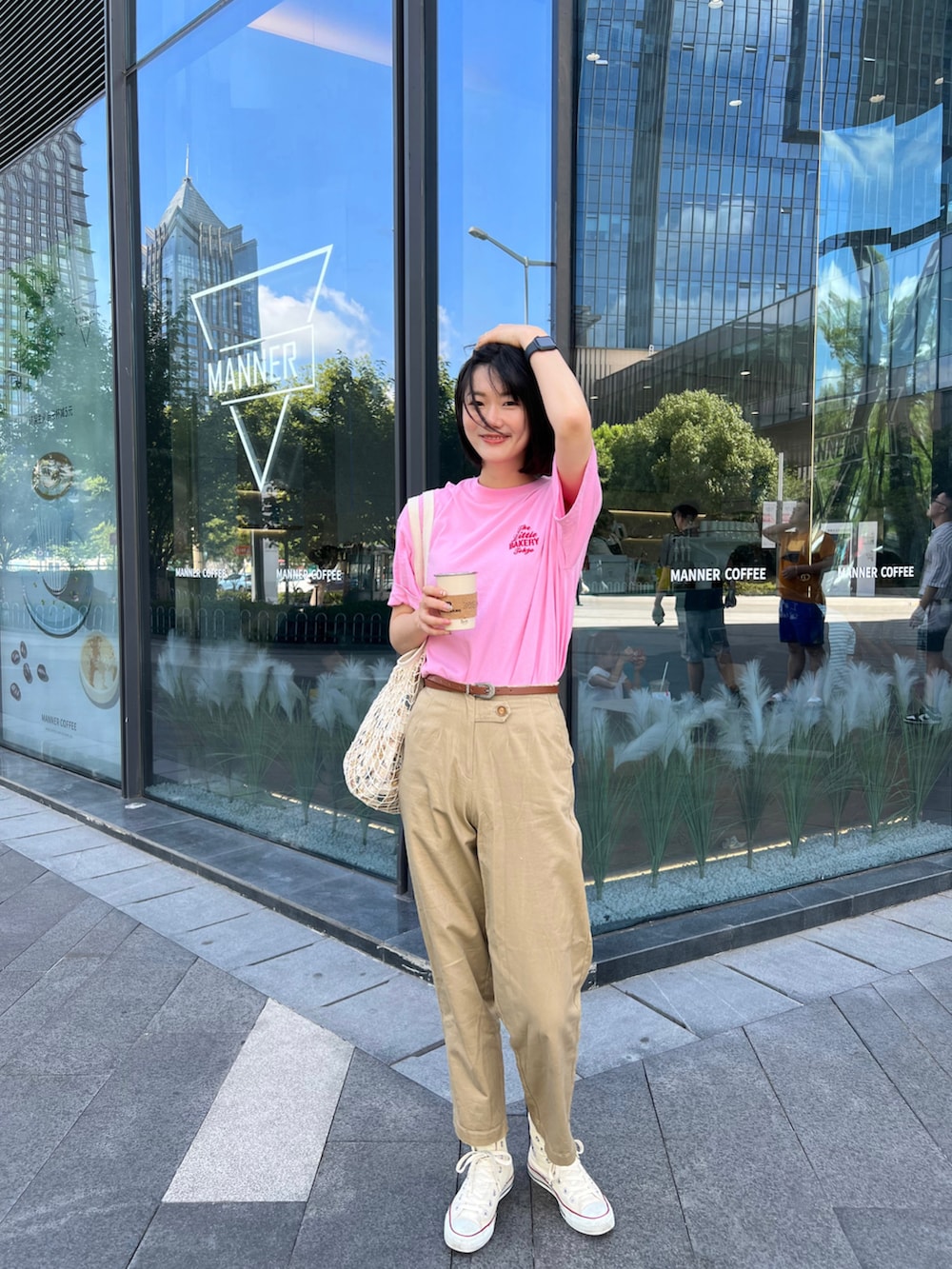 ホワイト系のスニーカー、ベージュ系のバッグ、ピンク系のTシャツ/カットソーを着用したレディースの夏コーディネートの2枚目の写真