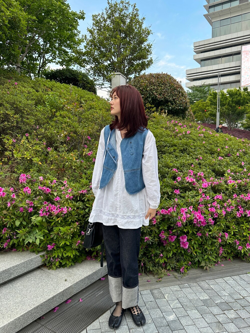 ブルー系のベスト、ホワイト系のシャツ/ブラウス、ブルー系のデニムパンツを着用したレディースの春コーディネートの3枚目の写真