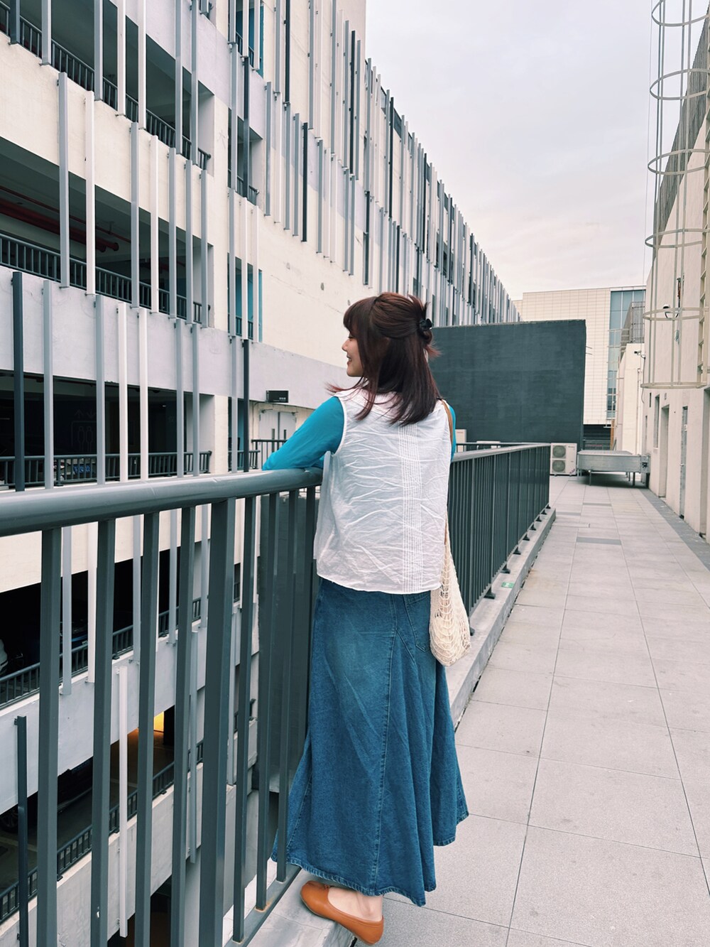 ホワイト系のシャツ/ブラウス、ブルー系のデニムスカート、ブルー系のTシャツ/カットソーを着用したレディースの春コーディネートの3枚目の写真