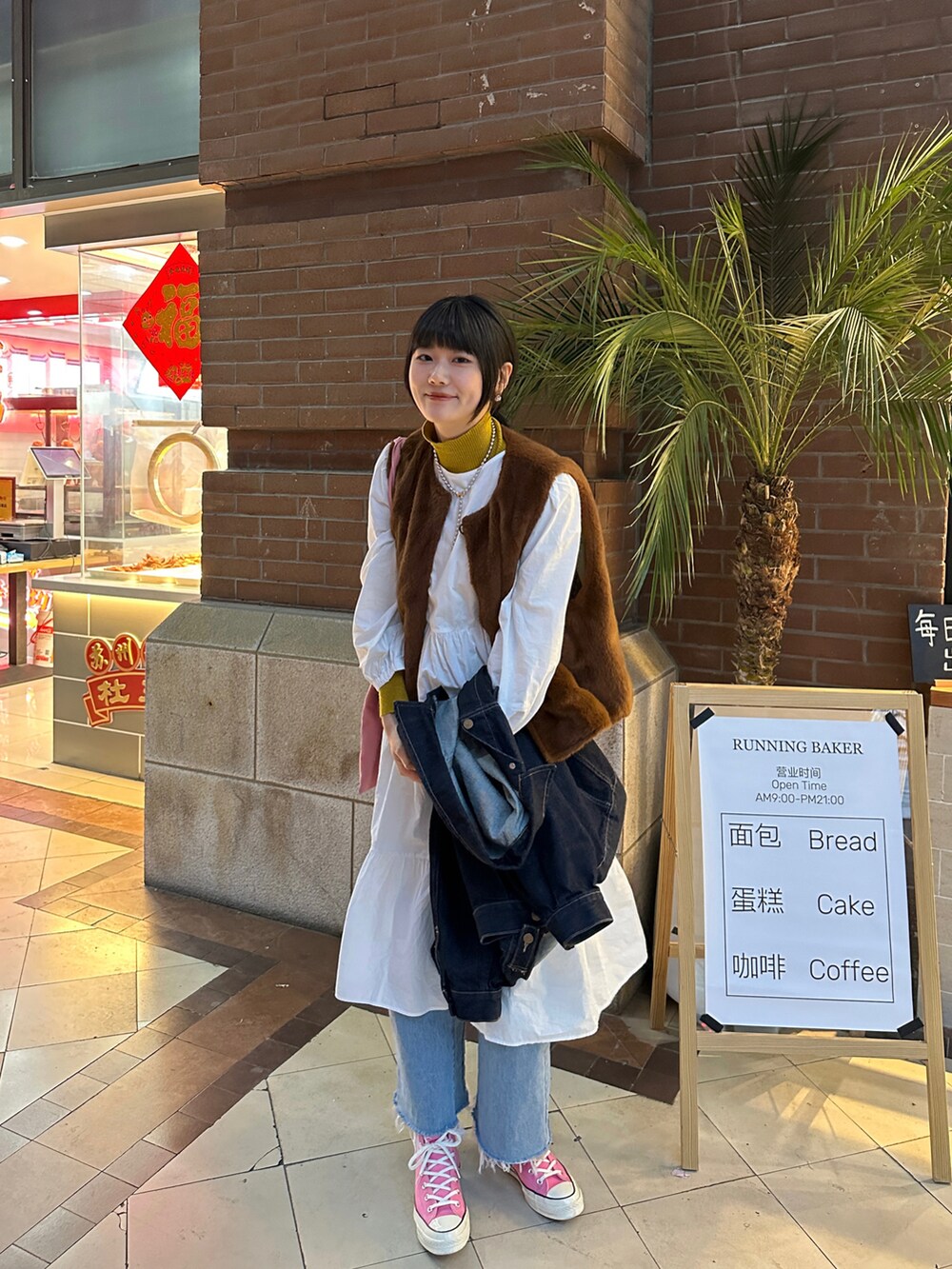 ブルー系のデニムジャケット、ピンク系のトートバッグ、ピンク系のスニーカーを着用したレディースの春コーディネートの2枚目の写真