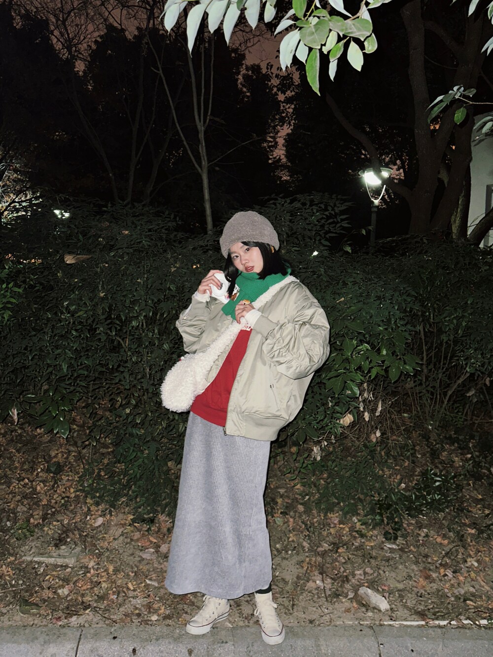 グリーン系のブルゾン、レッド系のスウェット、ホワイト系のTシャツ/カットソーを着用したレディースの冬コーディネートの2枚目の写真