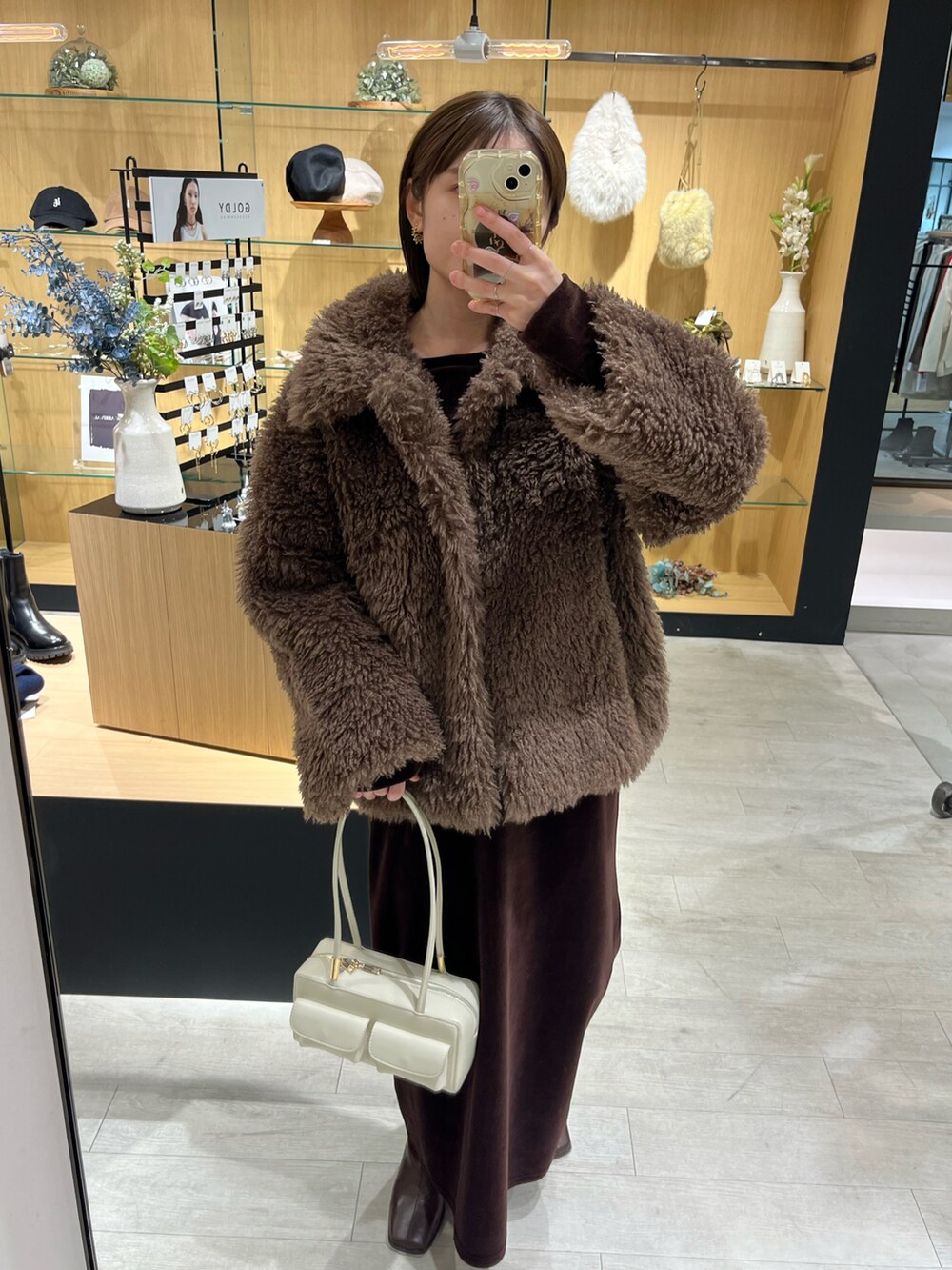 ホワイト系のバッグ、ブラウン系のその他アウター、ブラウン系のブーツを着用したレディースの冬コーディネートの2枚目の写真