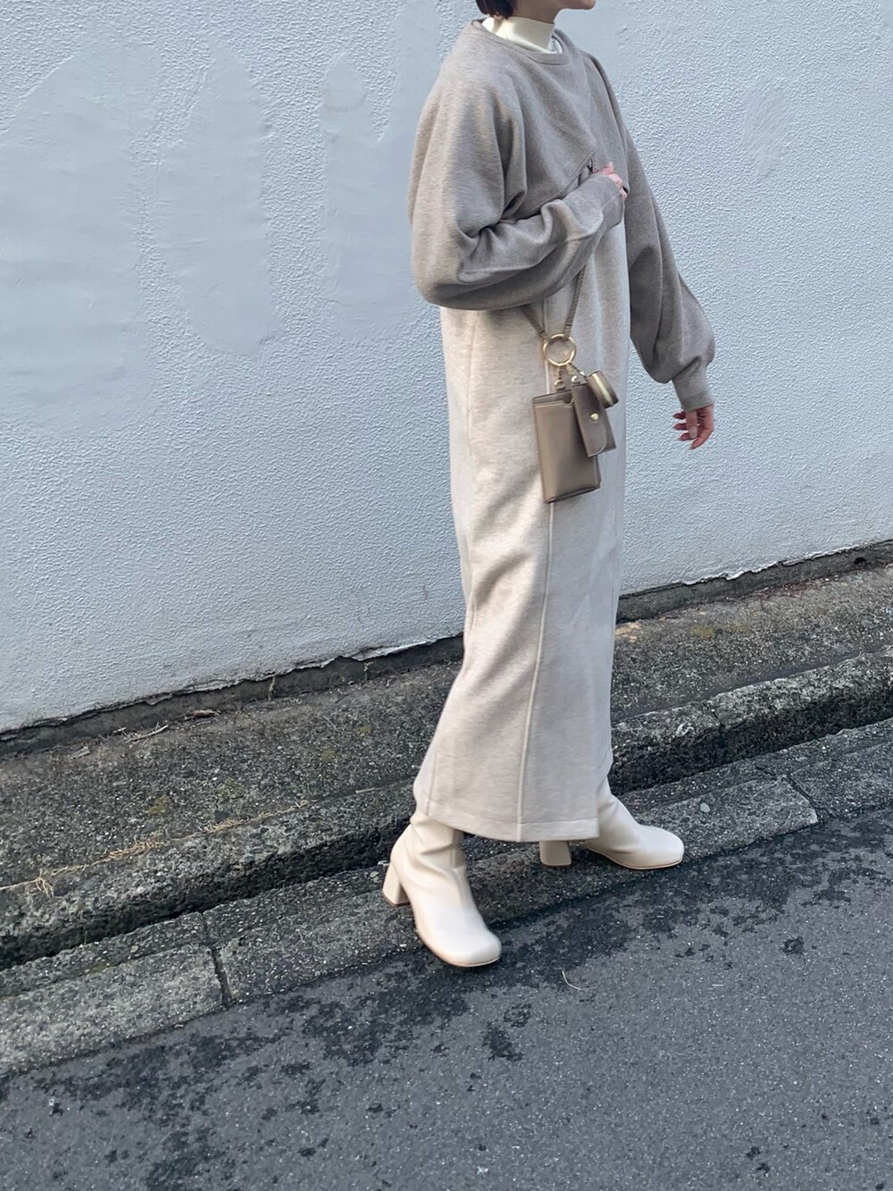 ホワイト系のブーツ、ブラック系のワンピース、ベージュ系のニット/セーターを着用したレディースの冬コーディネートの4枚目の写真