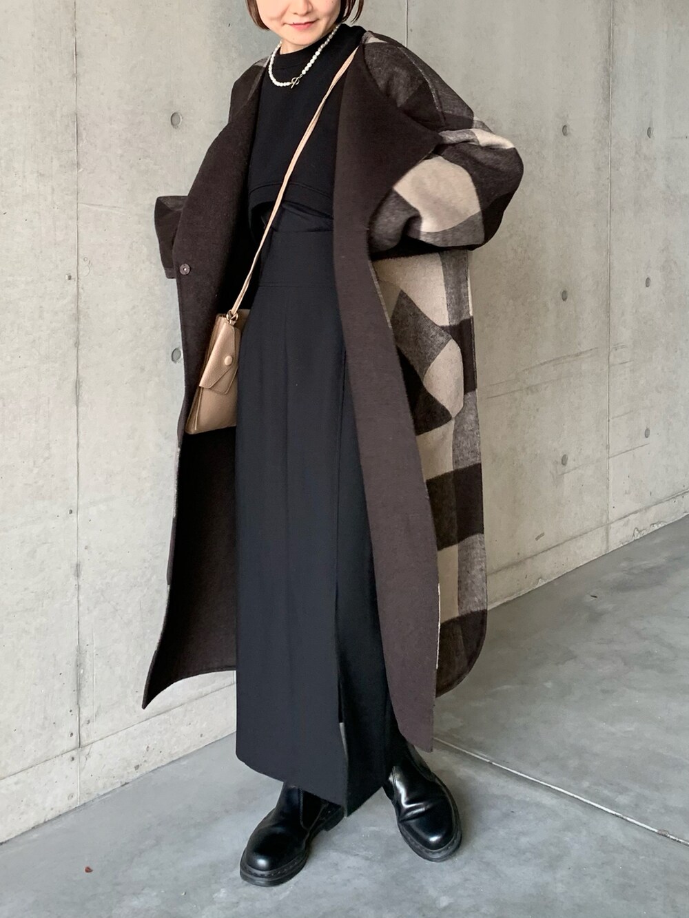 ブラック系のブーツ、ブラウン系のノーカラーコート、ブラック系のスカートを着用したレディースの秋コーディネートの5枚目の写真