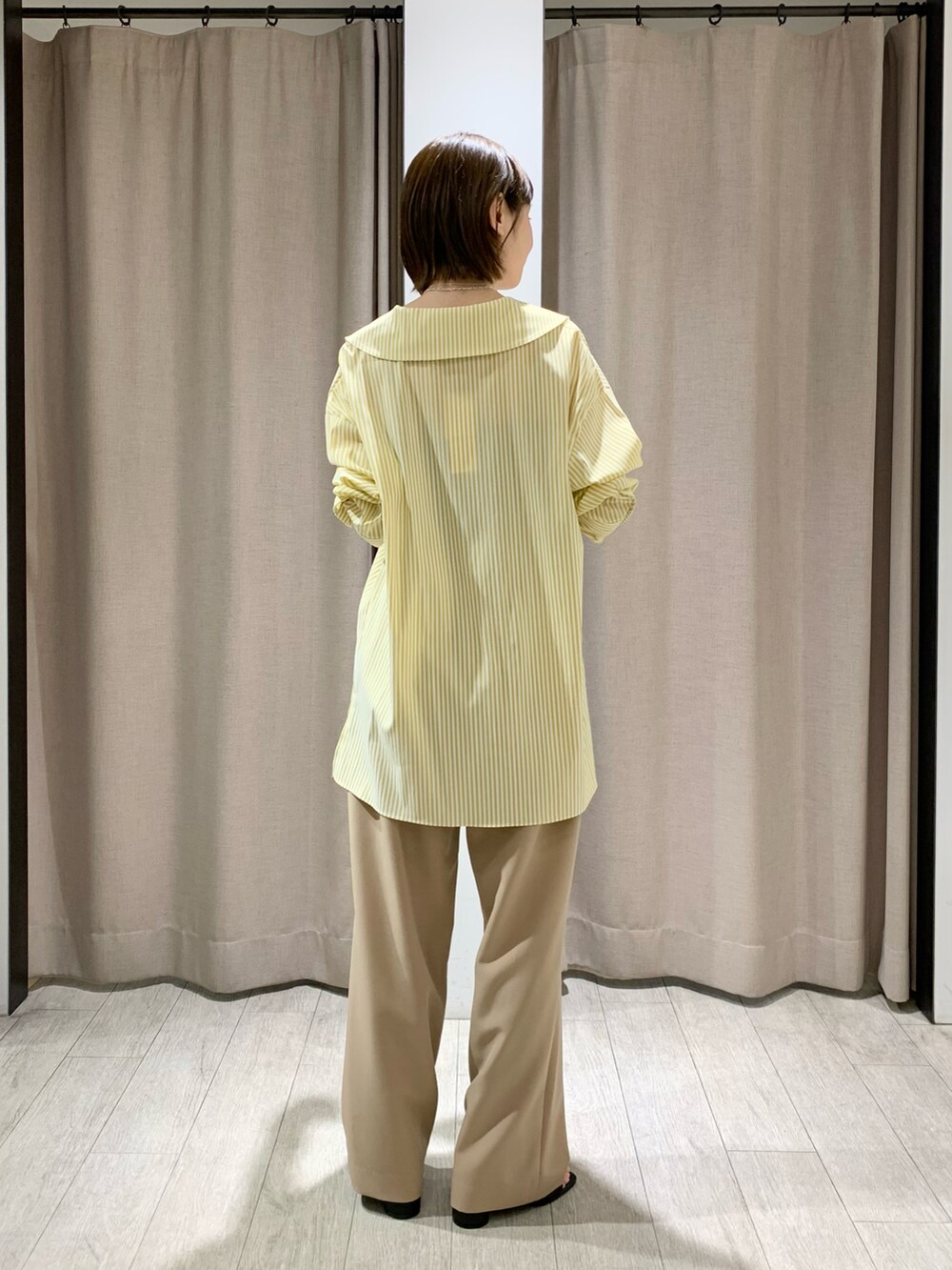 ブルー系のデニムパンツ、ブラック系のサンダル、ホワイト系のサンダルを着用したレディースの春コーディネートの4枚目の写真