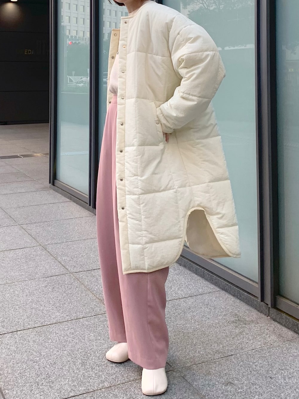 ピンク系のその他パンツ、ベージュ系のニット/セーター、ホワイト系のノーカラーコートを着用したレディースの冬コーディネートの3枚目の写真