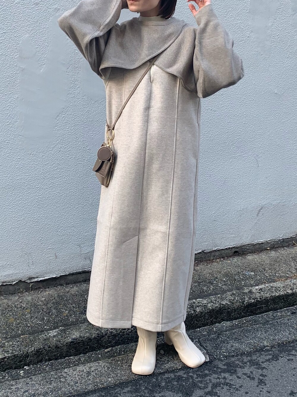 ホワイト系のブーツ、ブラック系のワンピース、ベージュ系のニット/セーターを着用したレディースの冬コーディネートの3枚目の写真