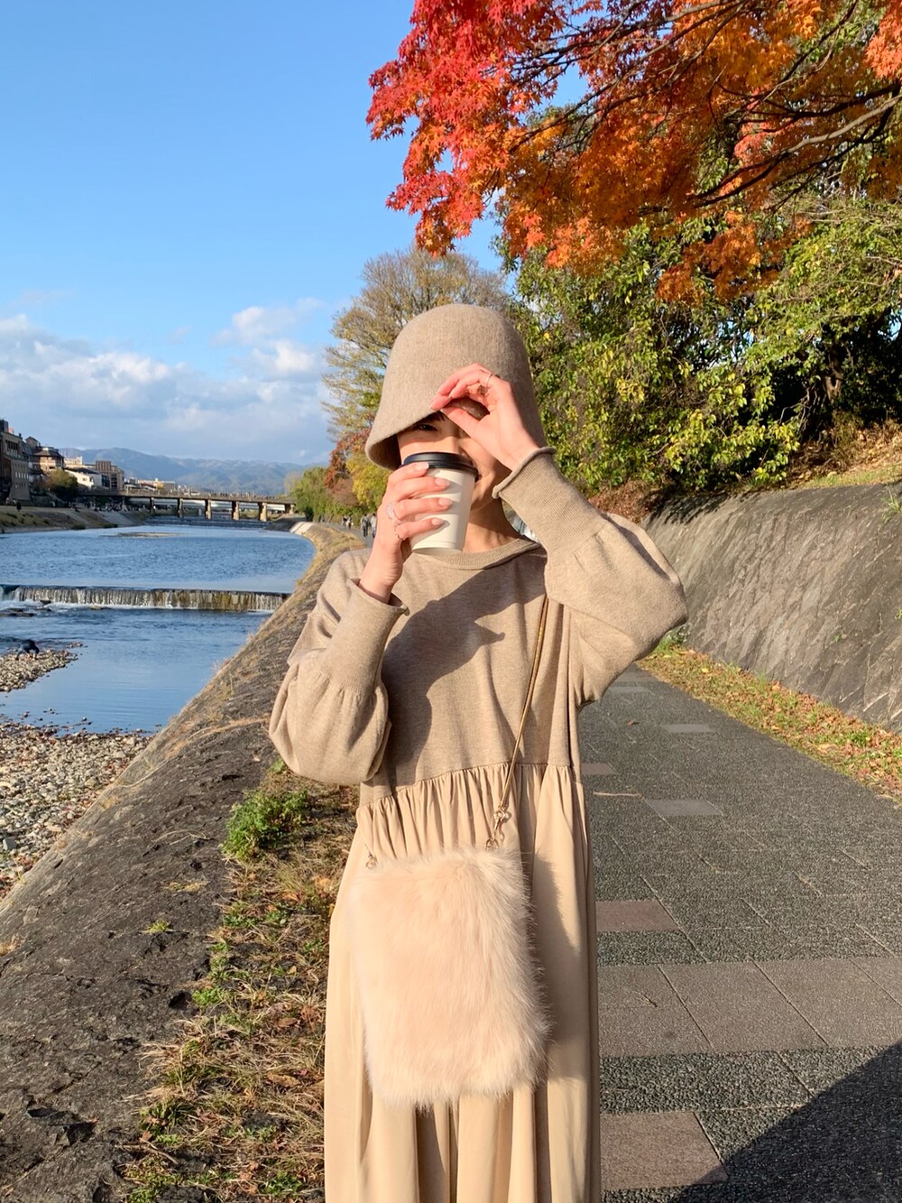 ベージュ系のスニーカー、ベージュ系のワンピース、ベージュ系のショルダーバッグを着用したレディースの秋コーディネートの4枚目の写真