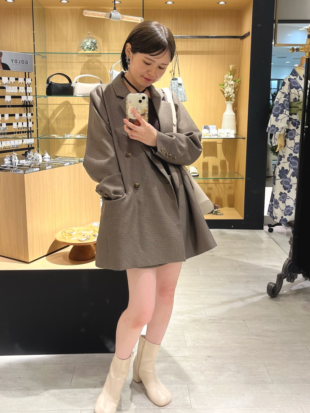 ブラウン系のテーラードジャケット、ブラウン系のニット/セーター、ホワイト系のトートバッグを着用したレディースの夏コーディネートの4枚目の写真