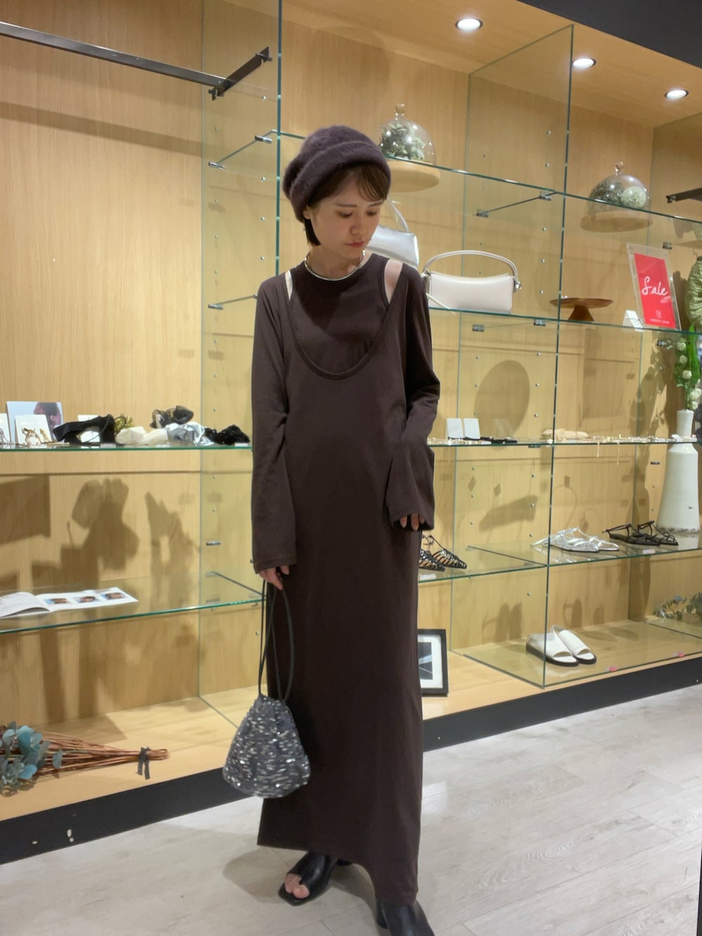 ブラウン系のワンピース、ブラック系のブーツ、その他のその他を着用したレディースの秋コーディネートの2枚目の写真