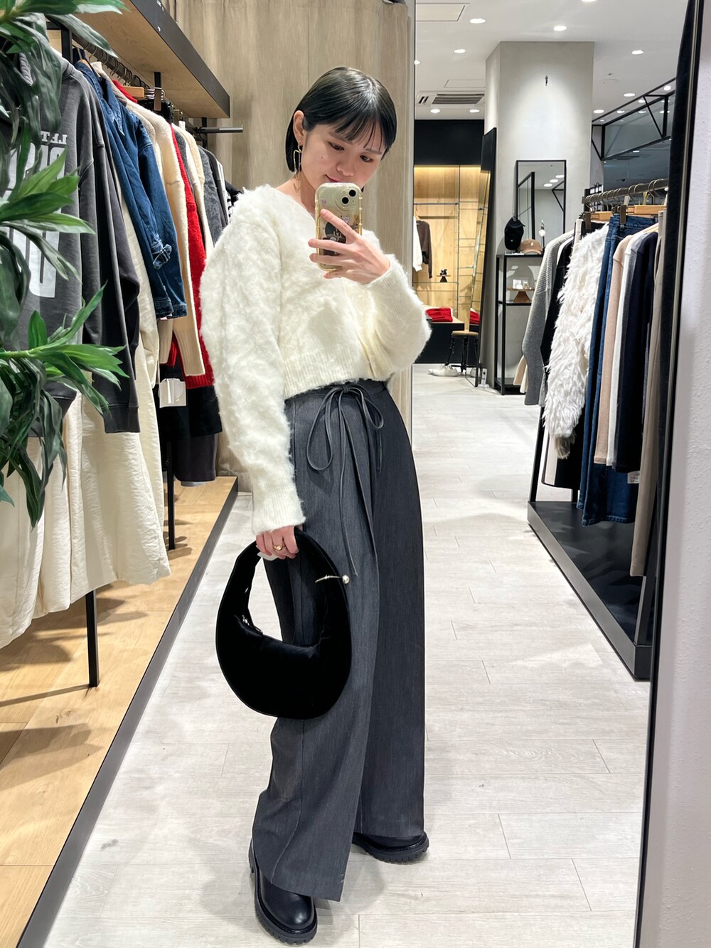 ブラック系のショルダーバッグ、ホワイト系のカーディガン/ボレロ、ブラック系のその他パンツを着用したレディースの冬コーディネートの4枚目の写真