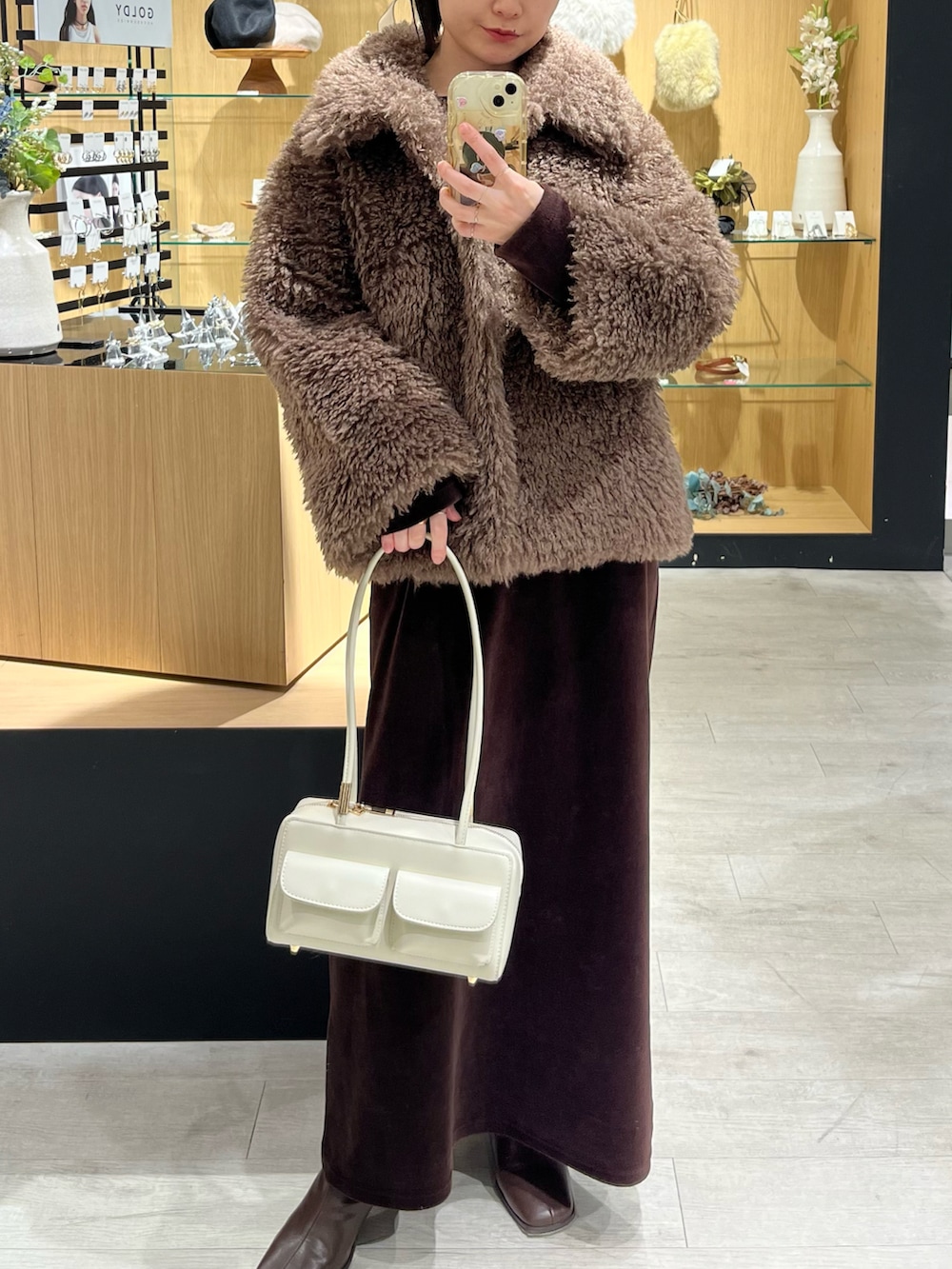 ホワイト系のバッグ、ブラウン系のその他アウター、ブラウン系のブーツを着用したレディースの冬コーディネートの5枚目の写真