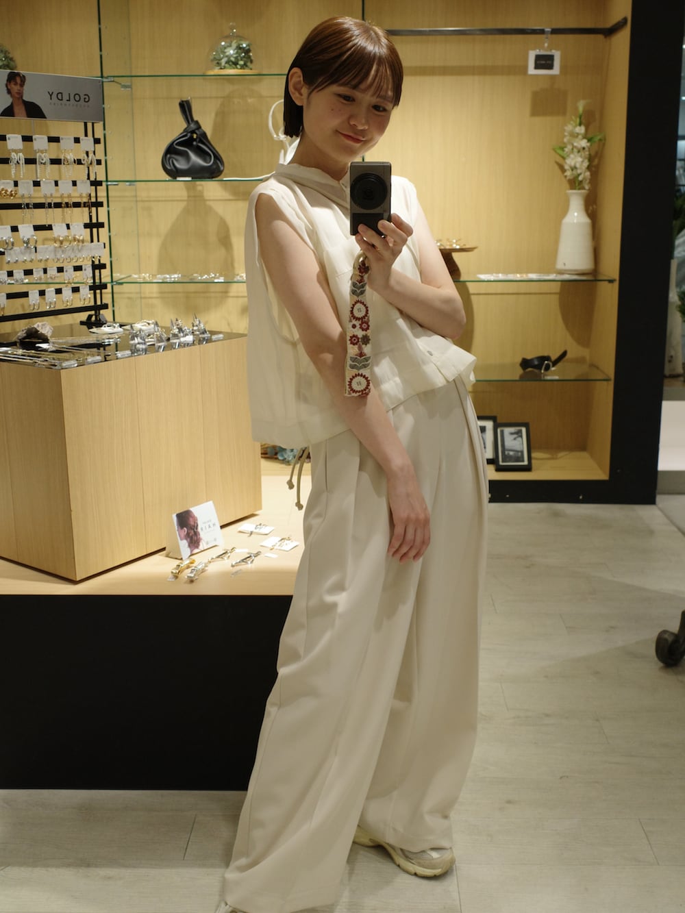 ホワイト系のその他パンツ、ホワイト系のシャツ/ブラウス、ブラック系のバッグを着用したレディースの夏コーディネートの2枚目の写真