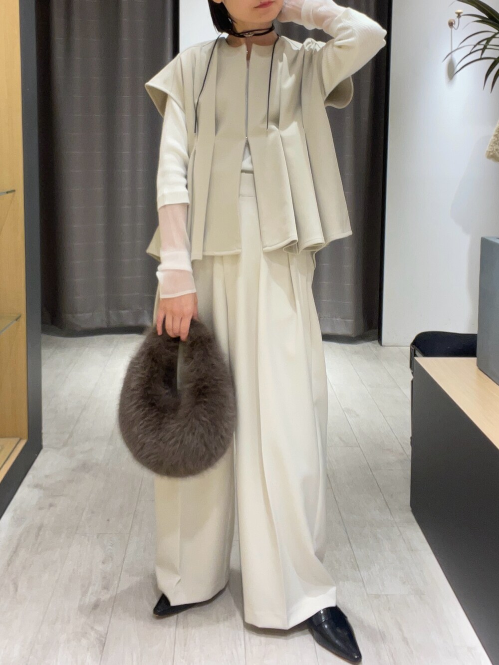 ベージュ系のベスト、ホワイト系のその他パンツ、ブラック系のパンプスを着用したレディースの秋コーディネートの2枚目の写真