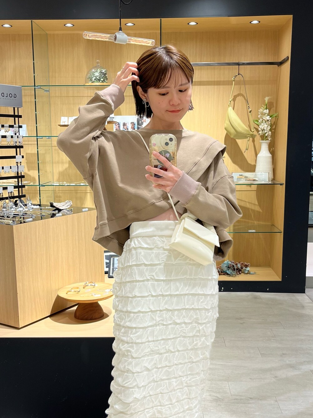 ブラウン系のTシャツ/カットソー、ホワイト系のスカート、シルバー系のサンダルを着用したレディースの秋コーディネートの5枚目の写真