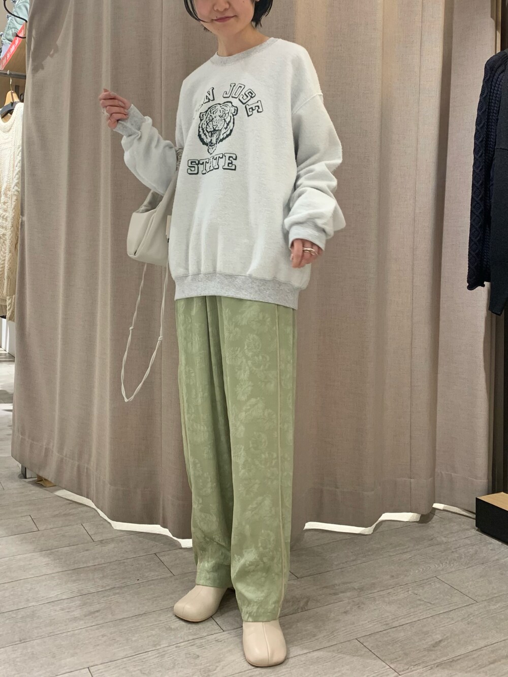 グリーン系のその他パンツ、グレー系のスウェット、ホワイト系のハンドバッグを着用したレディースの冬コーディネートの2枚目の写真