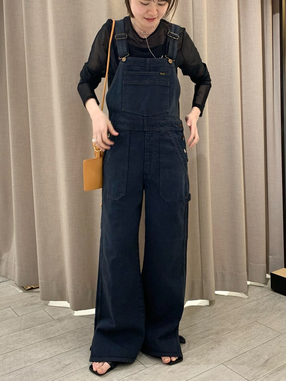 ブラック系のサロペット/オーバーオール、ブラック系のTシャツ/カットソー、ブラック系のサンダルを着用したレディースの春コーディネートの3枚目の写真