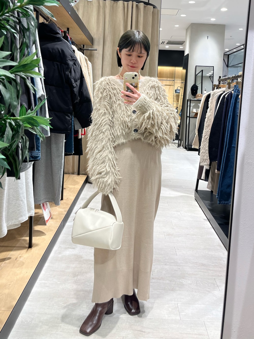 ブラウン系のブーツ、ベージュ系のワンピース、ベージュ系のカーディガン/ボレロを着用したレディースの冬コーディネートの3枚目の写真